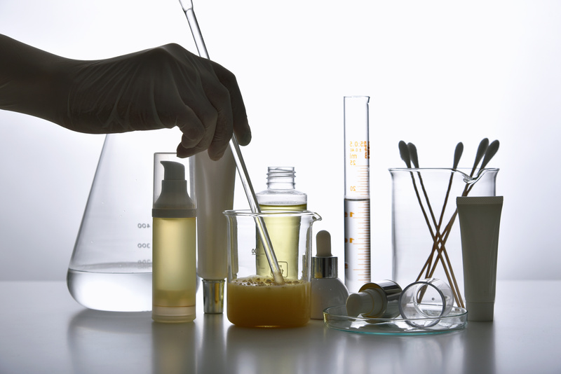 Dermatologist Formulating and Mixing Pharmaceutical Skincare, Cosmetic Blank Bottle Containers and Scientific Glassware